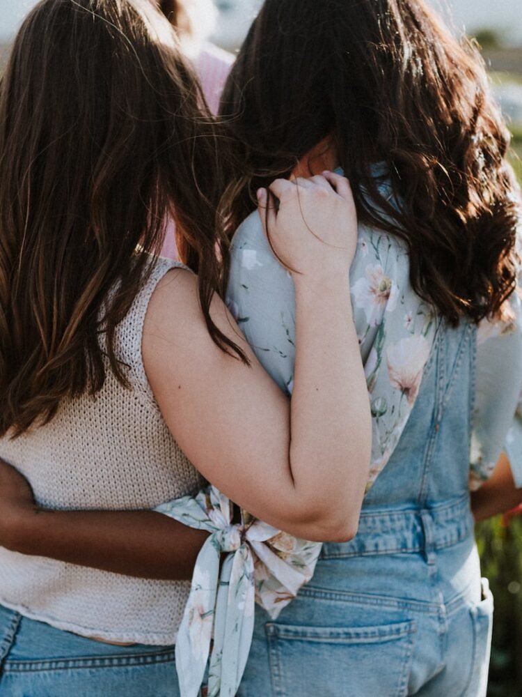 two women in front of flowers